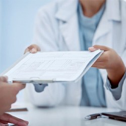 Medical team member handing clipboard to patient