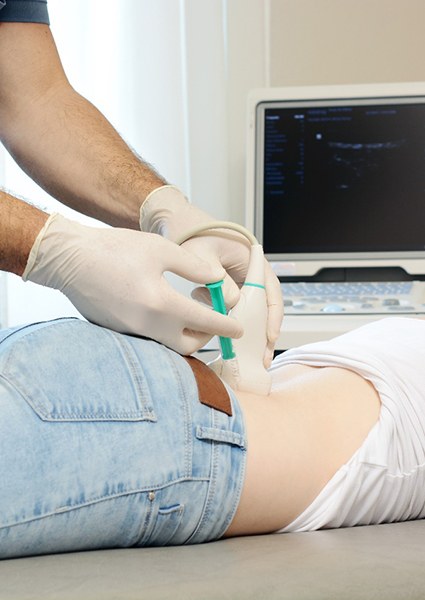 doctor injecting amniotic growth factors into woman’s lower back 