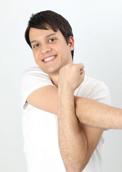 Man smiling and stretching his shoulder