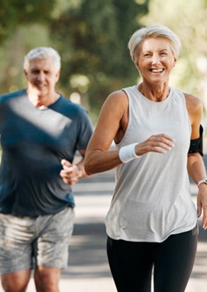 Mature couple jogging, enjoying the benefits of homeopathic orthopedics