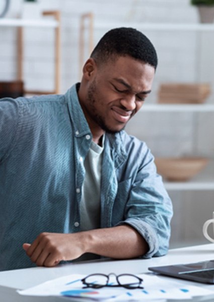 Man sitting at desk, suffering from back pain