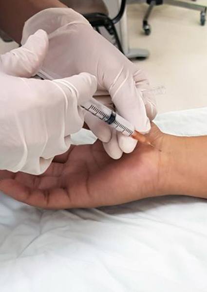 Doctor injecting solution into patient’s wrist