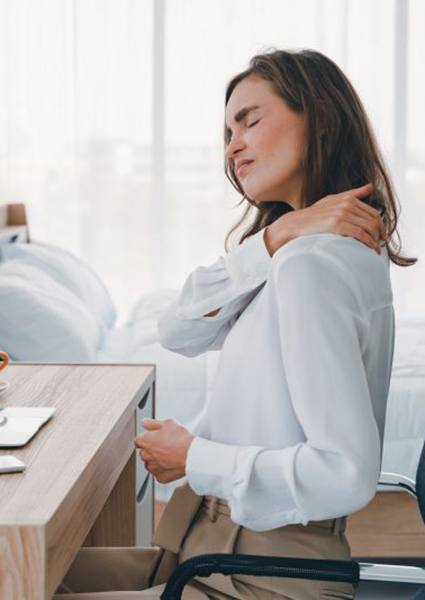 Woman sitting at desk, struggling with neck pain