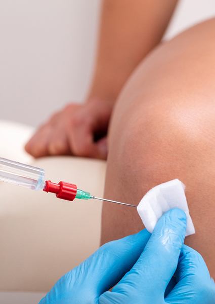 Close-up of patient’s knee receiving ozone injection