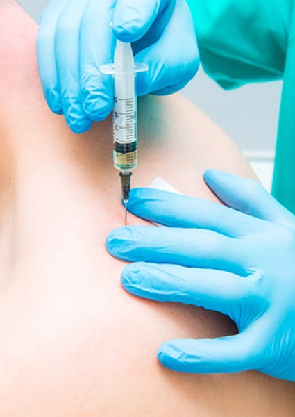 doctor injecting prolotherapy into patient’s shoulder