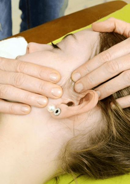 Osteopath examining patient’s TMJ